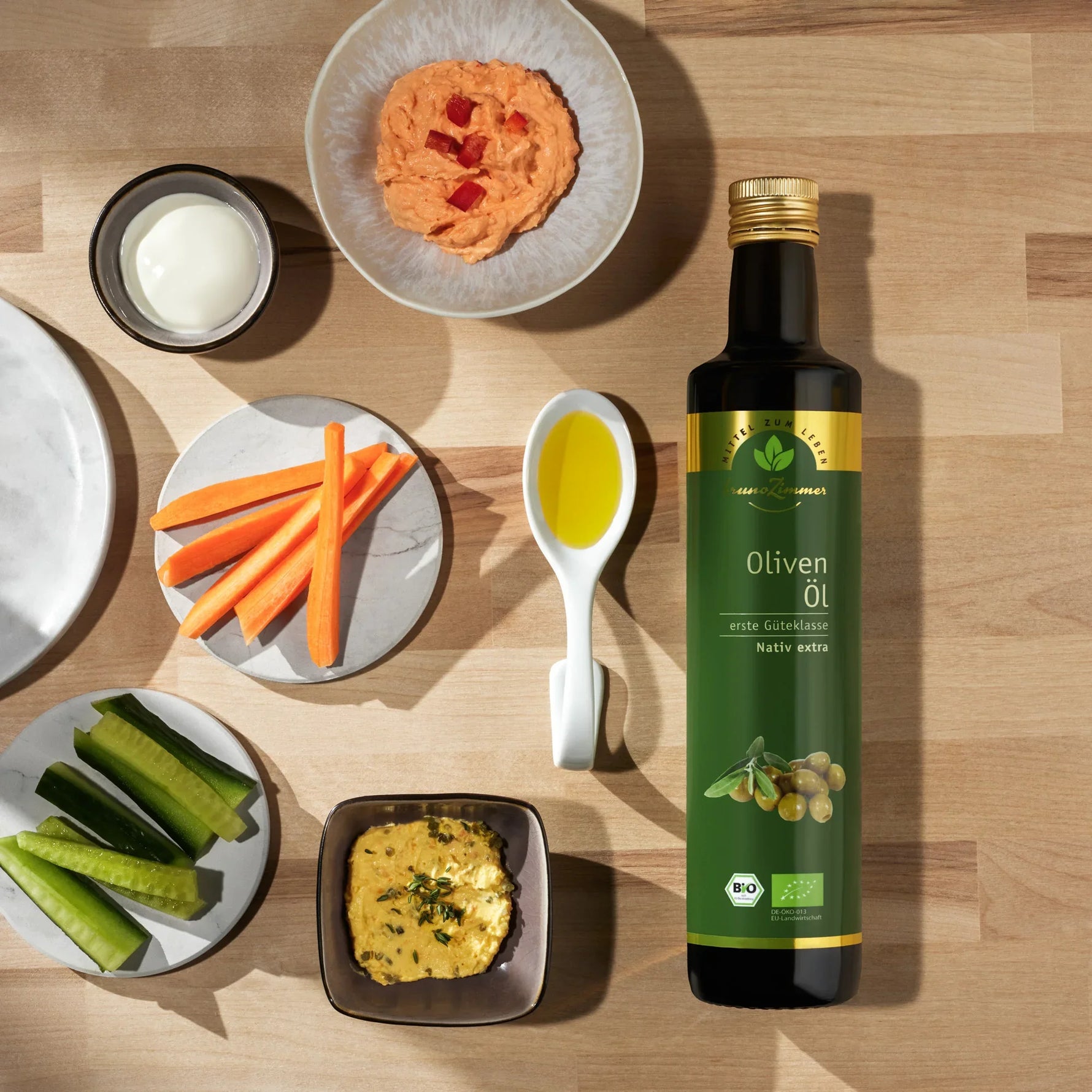 Bruno Zimmer Olivenöl 750ml – Flasche auf Tisch, frisches geschnittenes Gemüse, mediterrane Atmosphäre