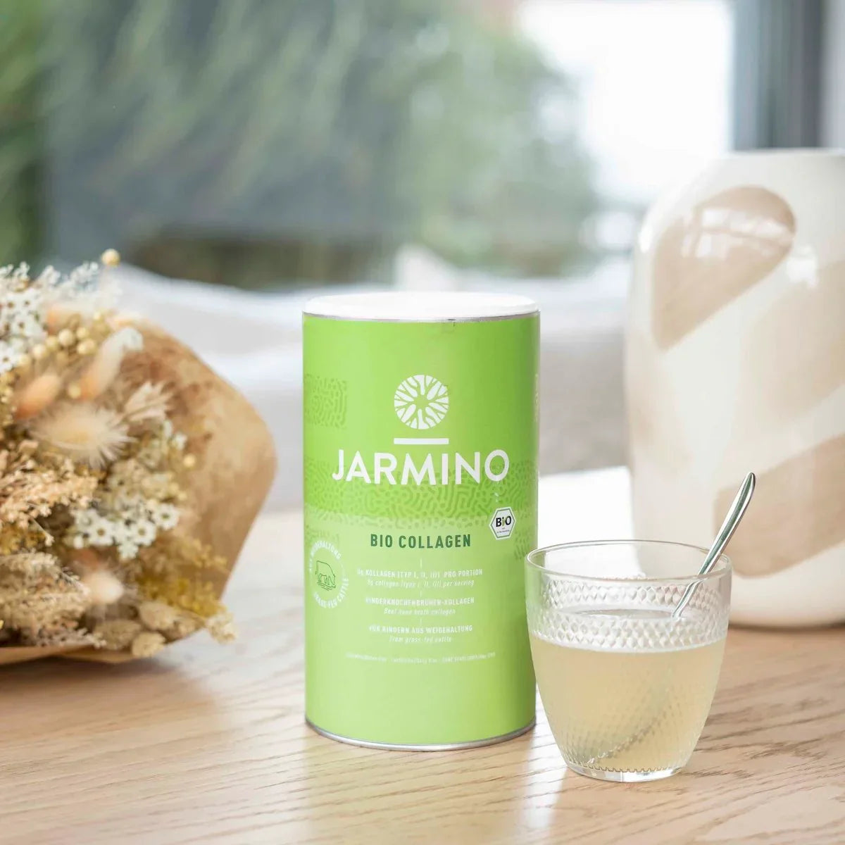 Jarmino Bio Kollagen 300g – Dose auf Tisch, Glas mit aufgelöstem Kollagen, Anwendung